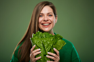 Close up face of smiling woman with romaine lettuce salad. Advertising female portrait on green.