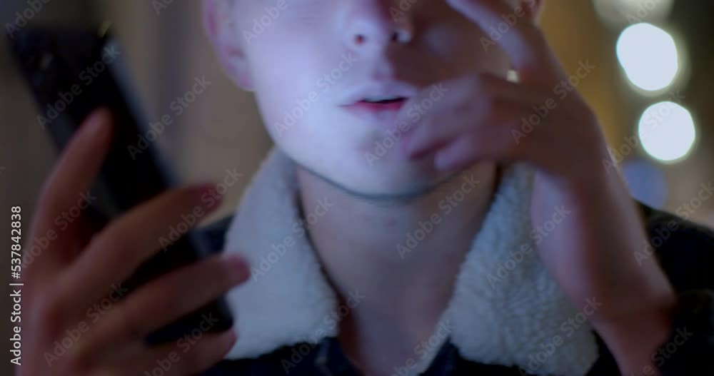 Poster a close-up of a guy holding a phone and counting an audio message while dancing. the screen light il