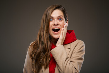 Excited young woman with surprising emotion wearing autumn coat, isolated female advertising portrait.