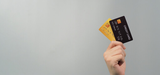 Hand is holding two credit cards isolated on grey background.