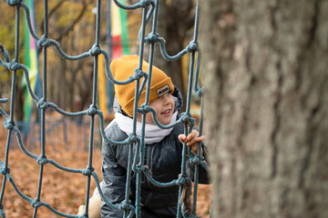 Closeup photography of boy, climbing on rope-ladder at the park.