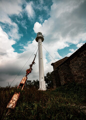An old white lighthouse with a red roof on the seashore Jarylgach island. Seascape with copy space. Postcard from travel.