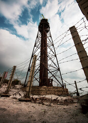 An old lighthouse with a red roof on the seashore Jarylgach island. Seascape with copy space. Postcard from travel.