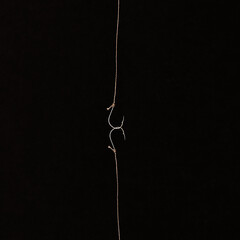 Fishing hook on a black background. trap, catch on, risk. Business concept idea