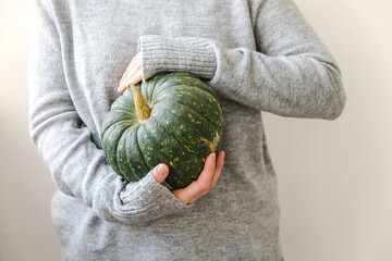 Autumnal Background. Unrecognizable woman hand holding in hands autumn fall pumpkin isolated on white background. Change of seasons ripe organic food, Halloween party Thanksgiving day
