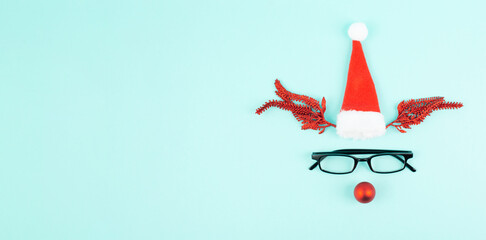 Reindeer with a red bauble nose, antlers, a santa claus hat and eyeglasses, merry christmas...