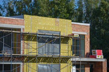 view of construction worker in doing insulation of wall at construction site