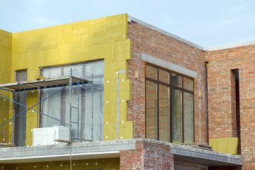 view of construction worker in doing insulation of wall at construction site