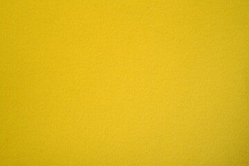 Photo of sheet of cardboard paper in solid golden yellow color. Munsell yellow hue background. 