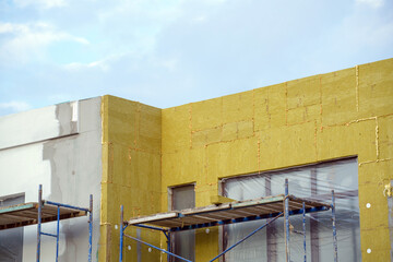 view of construction worker in doing insulation of wall at construction site