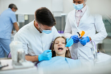 Teenage girl with dental braces having orthodontic treatment at dentist's office.