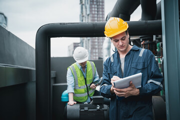 Engineer and team examining the air conditioning cooling system of a huge building or industrial...