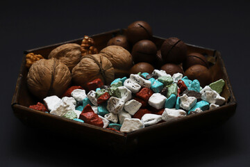 Sweets in the form of sea pebbles in a plate with nuts