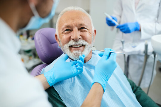 Happy senior man having dental treatment at dentist's office.