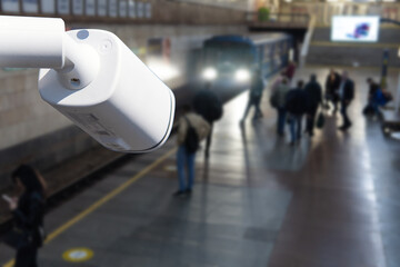 CCTV, security camera system operating with people waiting subway at train station, surveillance security and safety technology concept.