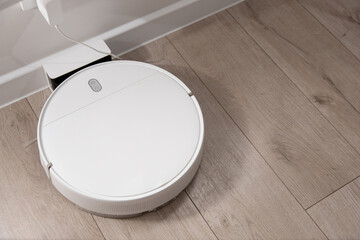 white robot vacuum cleaner stands at the charging station