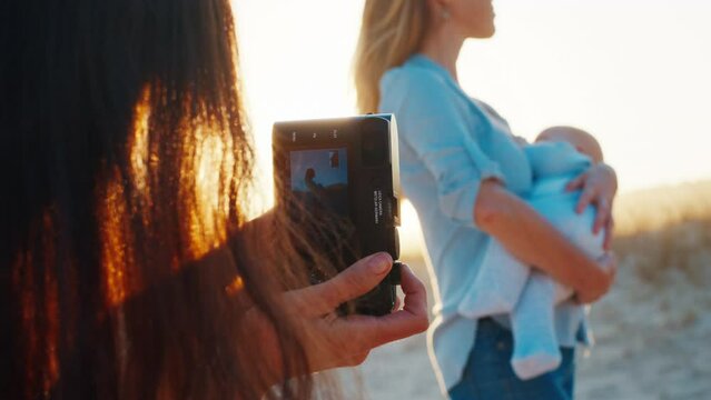 Family photographer. Photographer takes outdoor pictures of the woman with baby