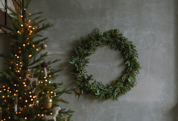 Beautiful huge wreath on the wall and Christmas lights. Loft apartment decorated for winter...