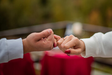 Two young people in love holding hands with rings. Engagement.