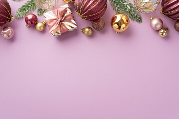 New Year celebration concept. Top view photo of pine branches in frost small stylish giftbox with ribbon bow pink transparent and gold baubles on isolated pastel lilac background with copyspace