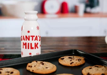 Raamstickers Closeup of a Santa's milk bottle with cookies on a wooden table © Tamara Sales/Wirestock Creators