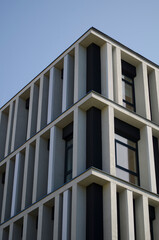 Facade of a building. a building against a blue sky. Modernist building. A high-rise building in a modern business center