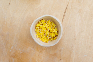 Top view of plastic tools with signs in bowl in pottery studio.