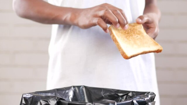 throwing bread in a garbage bin 