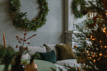 Stylish home interior with Christmas wreath and  Christmas tree, festive decorations for winter...