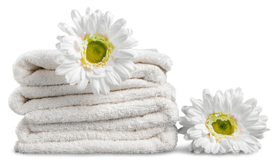 Pile of  fluffy towels with flowers on background