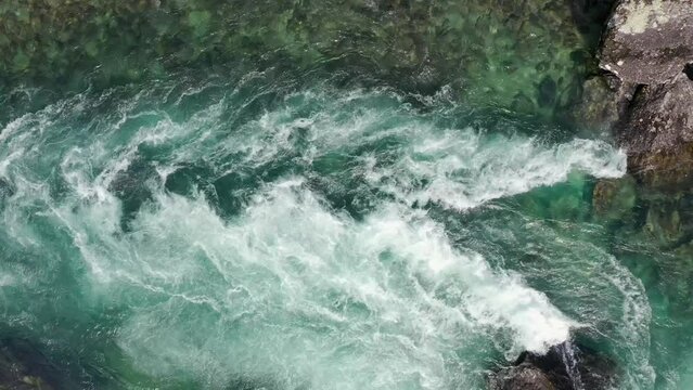 Aerial topdown view of powerful ocean current forming whirlpools and eddies,