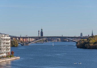 Fototapeta na wymiar Panorama view, island Essingen, Lux district on the island Lilla Essingen, office, skyscrapers, bridge Västerbron to the district Södemalm at a bay in the lake Mälaren a sunny a color full autumn day 
