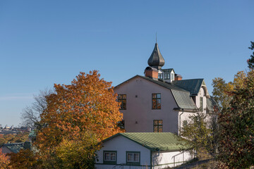 Fototapeta na wymiar Old 1904s apartment building with an onion dome, on the hill Ormberget a sunny a color full autumn day in Stockholm