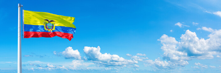 Ecuador flag waving on a blue sky in beautiful clouds - Horizontal banner