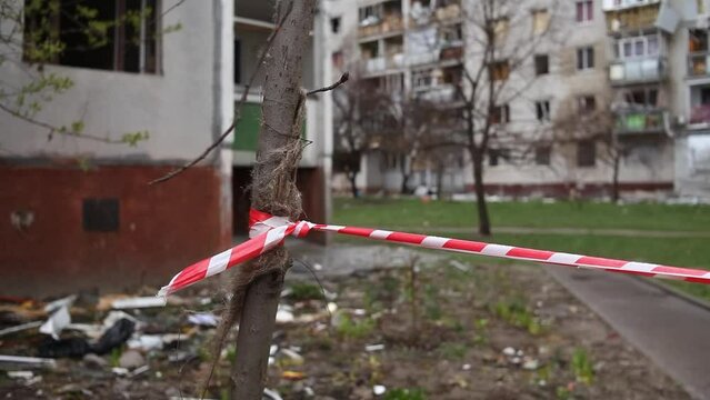 Enclosing red-white signal tape area near a destroyed residential building after the bombing of the Ukrainian city by Russian aircraft. Ruins of city Chernihiv of terrorist attacks, bomb shelling.