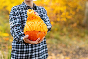 Cozy autumn photo of a teen boy with pumpkin outdoor. Halloween and Thanksgiving day. Beautiful autumn day. Thanksgiving holiday season. Teenager boy ready for outdoor Halloween Party.