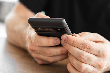 Close-up, male hands with a smartphone, detail of the rear cameras.
