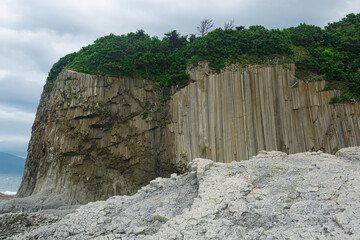 columnar basalt rock, Cape Stolbchaty on Kunashir Island, in the foreground bases of lava basalt columns form a kind of pavement
