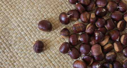 Raw chestnuts on a wicker napkin.