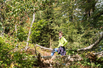 Naklejka na ściany i meble young boy trekking in the forest looking for caches