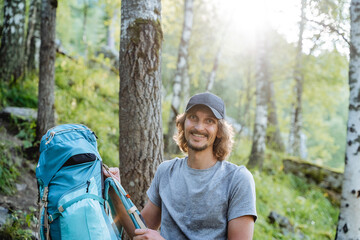 The guy goes to the camera a young cheerful male traveler, the glare of the sun behind the man, a...