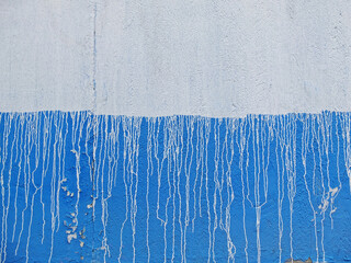 Blue and white concrete wall with white streaks of paint as background or texture