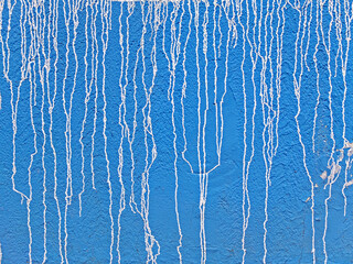 Blue concrete wall with white streaks of paint as background or texture