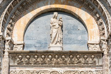 Fototapeta na wymiar Close-up on Madonna´s marble statue decorating the exterior facade of catholic basilica in Pisa