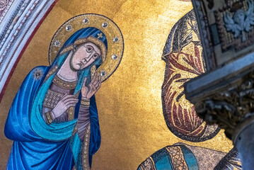 Close-up on golden fresco portraiting Virgin Mary in blue