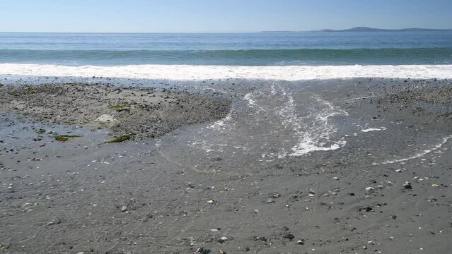 Sea water being swept onto beach by successive breaking waves