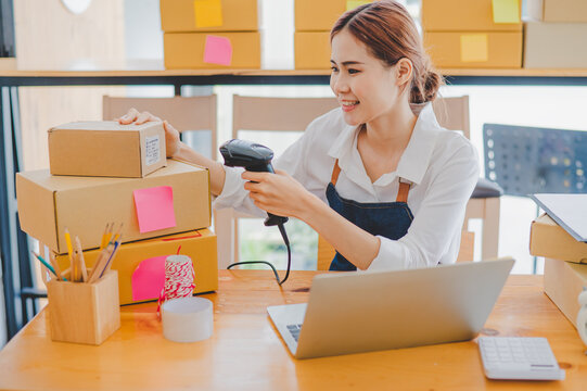 Small business owners online are scanning barcode-labelled parcel boxes with a barcode scanner to verify their product orders. of online retailers - online shopping