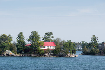 Cottage with a red metal roof on a rocky island
