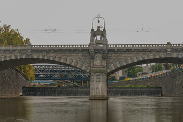 Fototapeta premium Radbuza river with big weir and car bridge in autumn cloudy day