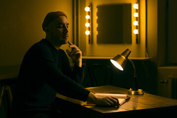 man sitting in a dark room reading a book